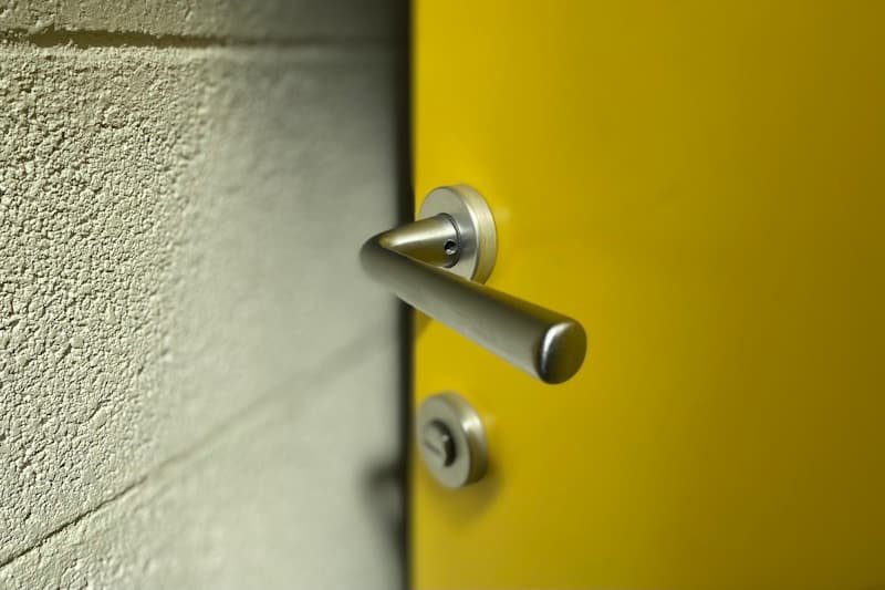 Stainless steel lever handle and cylinder lock on a door